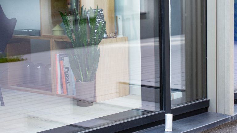 Eine Wetterstation des Anbieters Netatmo steht außen vor einer Verandatür.