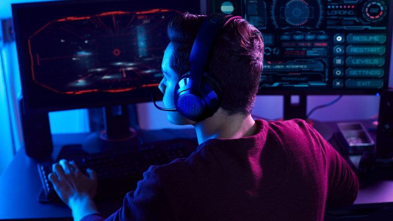 JBL Quantum 350 Wireless Eine Person spielt an einem Computer und trägt dabei das Headset JBL Quantum 350 Wireless.