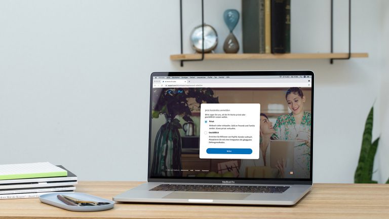 Auf einem Schreibtisch steht ein Laptop, auf dem eine Seite der PayPal-Kontoeinrichtung geöffnet ist. Auf einem Schreibtisch steht ein Laptop, auf dem eine Seite der PayPal-Kontoeinrichtung geöffnet ist.