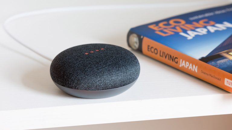 Ein Google Nest Mini steht auf einem weißen Tisch.