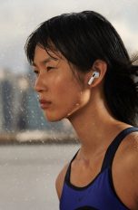 Eine Person ist mit den neuen AirPods der dritten Generation im Regen unterwegs.
