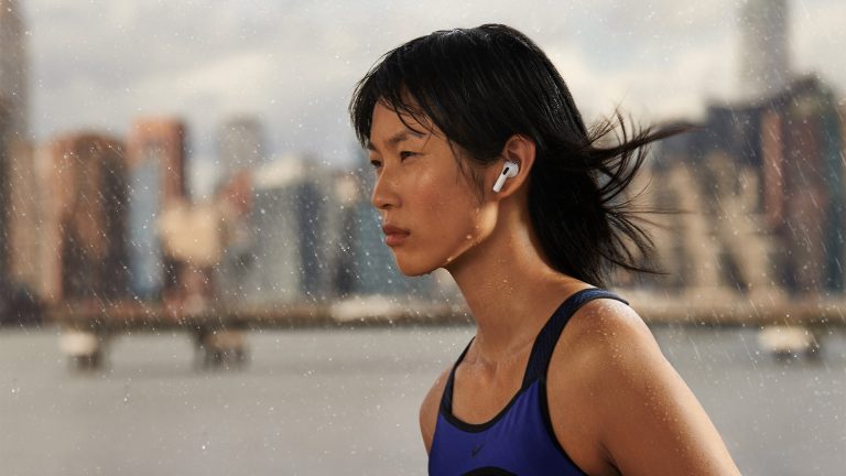 Eine Person ist mit den neuen AirPods der dritten Generation im Regen unterwegs.