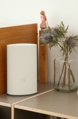 Ein Huawei-Router steht auf einem Regal zwischen diversen Deko-Artikeln.