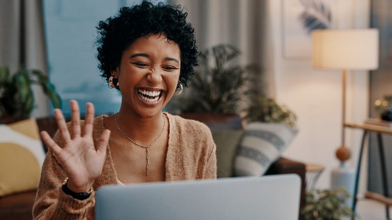Snap Camera Eine Person sitzt vor einem Rechner und lächelt in die Kamera.