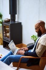 Eine Person hat einen Laptop auf dem Schoß.