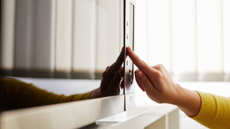 Inverter-Mikrowelle Eine Hand tippt auf eine Taste an einer Mikrowelle.