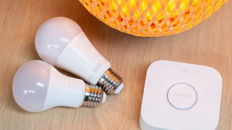 Philips Hue Zwei smarte Glühbirnen neben einer Philips-Hue-Bridge.
