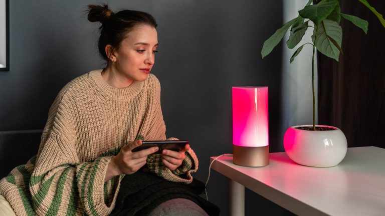 Matter Eine Person steuert mit ihrem Smartphone eine Lampe.