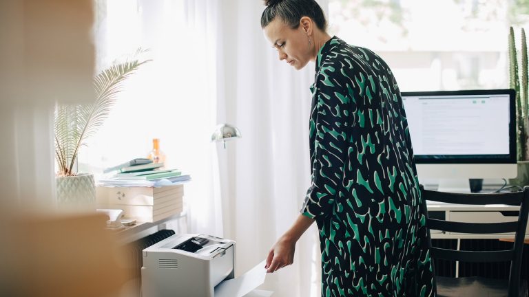 Multifunktionsdrucker Eine Person holt einen Druck aus einem Multifunktionsdrucker.