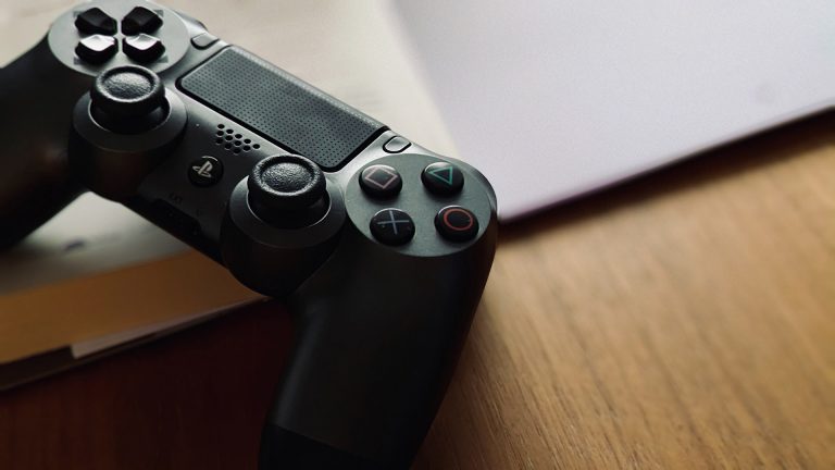 PS4-Controller verbindet sich nicht Ein DualShock-4-Controller in leichter Draufsicht liegt auf einem Holztisch.