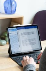 Eine Person sitzt vor einem iPad Pro und nutzt den Stage Manager.