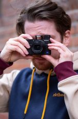 Eine Person hält die Sony Cyber-Shot DSC-RX100M3 in der Hand und macht ein Foto in Richtung Kamera.