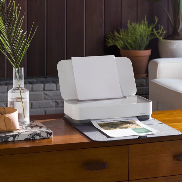 Der HP-Drucker Tango X steht auf einer Kommode. In der Ablage liegt ein Ausdruck.