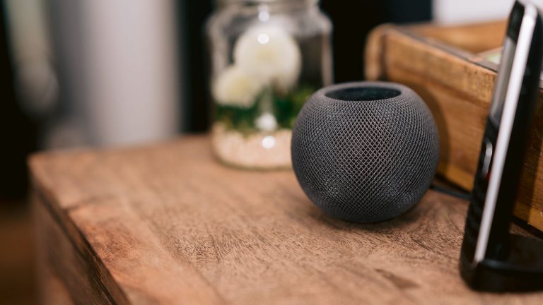 Smarte Lichterkette für den Weihnachtsbaum Ein Home Pod steht auf Holzkommode.