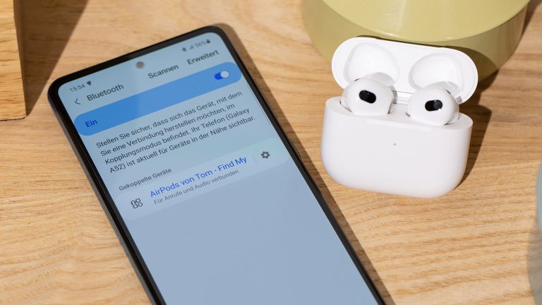 AirPods unter Android nutzen Auf einem Android-Smartphone sind die Bluetooth-Einstellungen geöffnet. Daneben befindet sich ein AirPod-Case, dessen Deckel aufgeklappt ist.