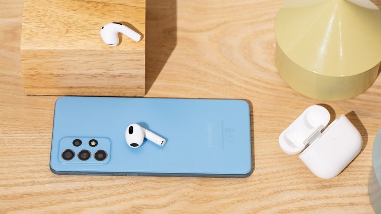 AirPods unter Android nutzen Ein Android-Smartphone, ein paar AirPods und das Case liegen auf einem Tisch.
