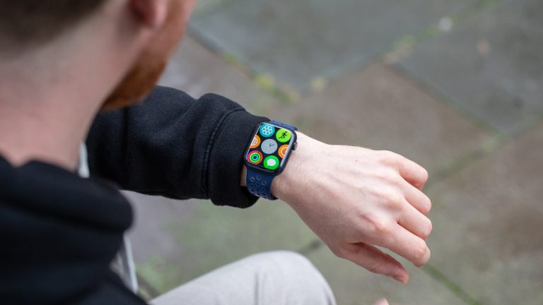 (Eine Person trägt eine Apple Watch und schaut darauf.
