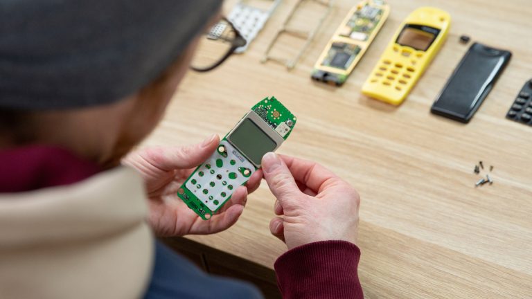 Nokia 5110 Bilderrahmen Eine Person entfernt das aufgesteckte LC-Display von der Platine eines Nokia 5110.