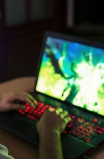 Eine Person spielt etwas an einem Gaming-Notebook.