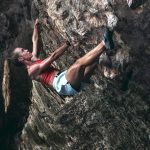 Eine Person klettert einen Berg hinauf. Sie trägt eine Smartwatch von Garmin.