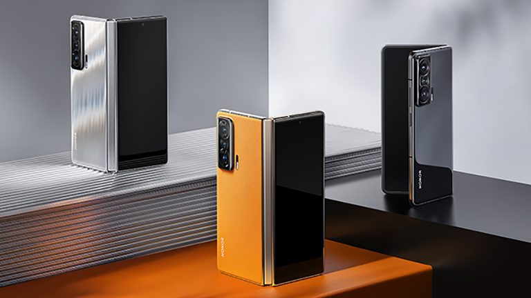 Honor Magic V Drei halb geöffnete Honor Magic V stehen dekorativ auf farblich passendem Interieur.