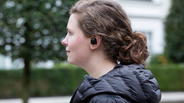 Seitenaufnahme einer Person, die die Sony WF 1000XM4 Bluetooth-Kopfhörer trägt.