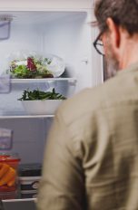 Eine Person blickt in einen Kühlschrank.