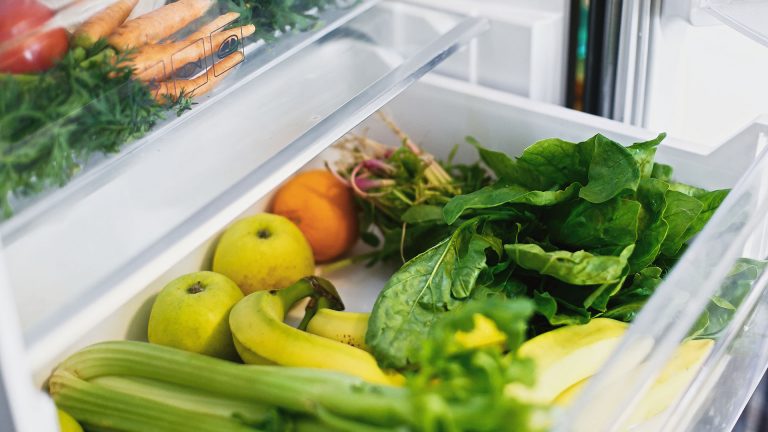 Wasser im Kühlschrank Nahaufnahme eines geöffneten und gut gefüllten Gemüsefachs in einem Kühlschrank.