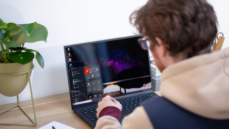 Eine Person sitzt vor einem Ultrabook mit Windows-Betriebssystem.
