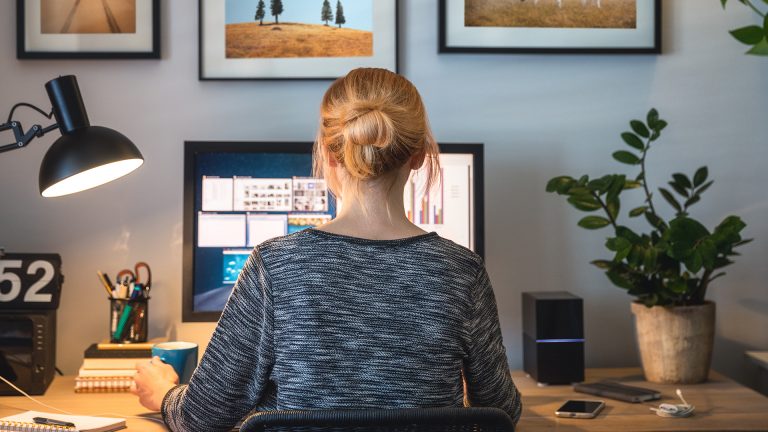 PC-Lautsprecher Eine Person sitzt an einem Schreibtisch vor einem Bildschirm und arbeitet.