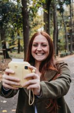 Eine Person nimmt ein Selfie mit einer Sofortbildkamera auf.