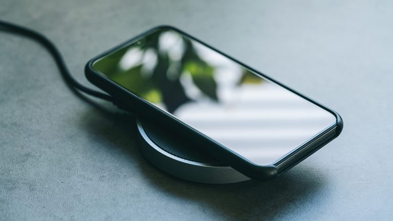 induktives Laden Ein Smartphone liegt auf einer induktiven Ladestation und lädt.