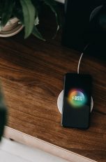 Ein Smartphone liegt auf einer induktiven Ladestation und lädt.