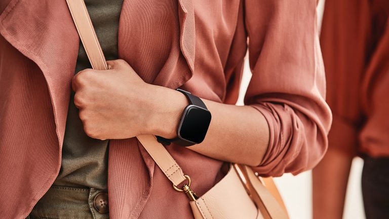 Fitbit Versa 2 Eine Person im Alltags-Outfit trägt am linken Arm eine Fitbit Versa 2.