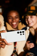 Drei Personen lachen in die Frontkamera eines Galaxy S22 Ultra.