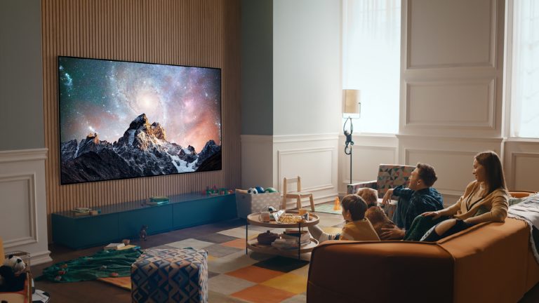 Smart TV Eine Gruppe von Personen sitzt vor einem LG Evo und schaut auf das Display.