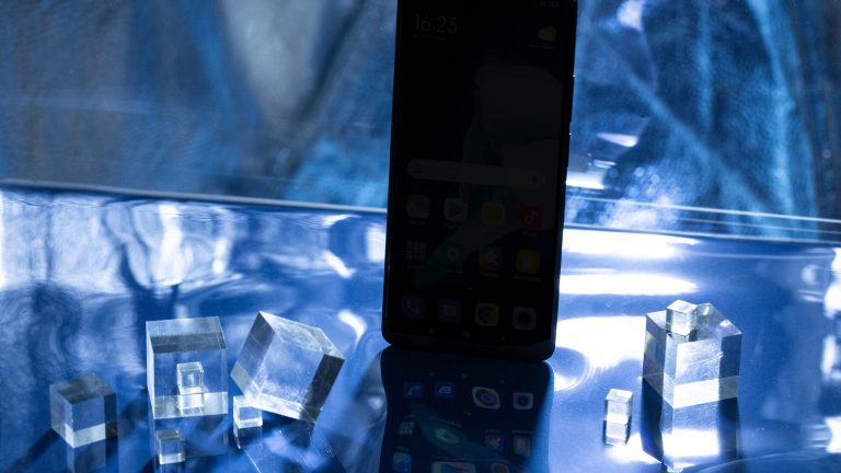 Ein Smartphone steht ihn einer mystisch wirkenden Kulisse.