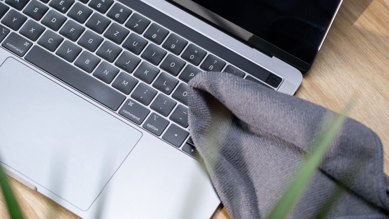 Tastatur reinigen Ein Mikrofasertuch liegt auf der Tastatur eines MacBooks.