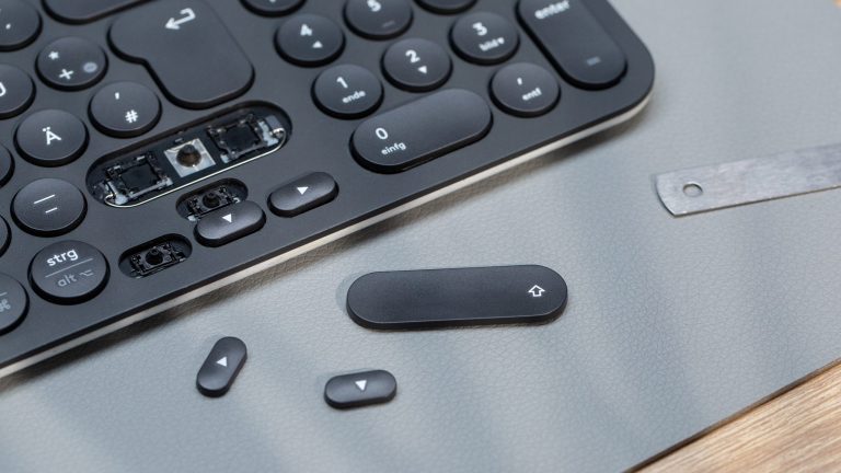 Tastatur reinigen Vor einer Tastatur liegen gelöste Tasten.