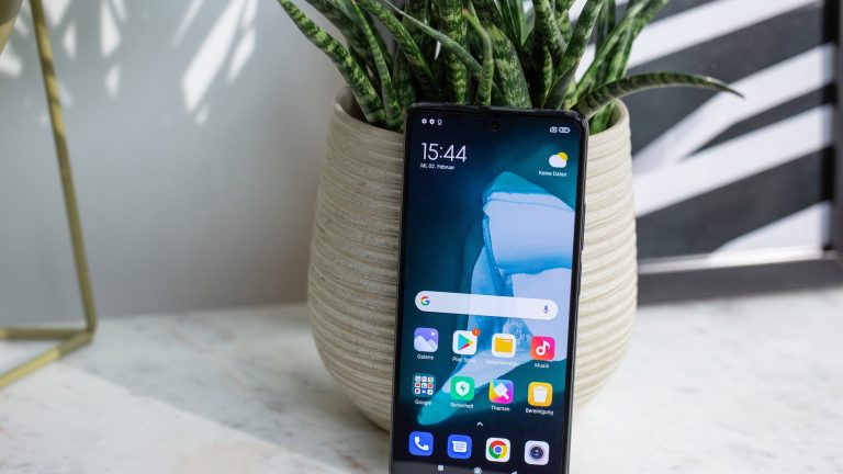 Xiaomi Mi 10T Ein Redmi 11T Pro lehnt auf einer Marmorplatte stehend an einem Blumentopf.