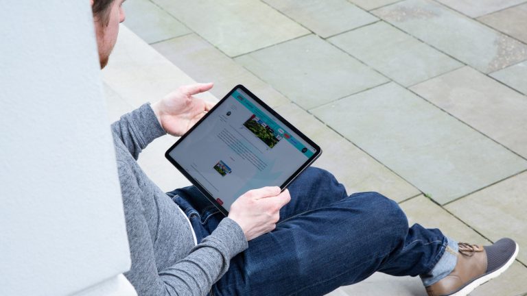Screenshot am iPad Eine Person hält ein iPad Pro in der Hand.