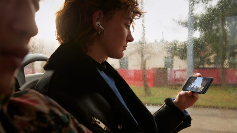 iPhone SE 5G Eine Person sitzt in einem Bus und schaut ein Video auf einem iPhone SE.