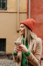 Eine Person steht mit ihrem Smartphone auf der Straße.