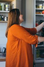 Eine Person öffnet einen Kühlschrank.