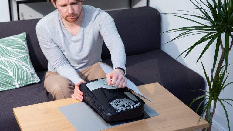 PlayStation 5: So wechselst du die Seitenteile Eine Person hebt ein Seitenteil von einer PlayStation 5.