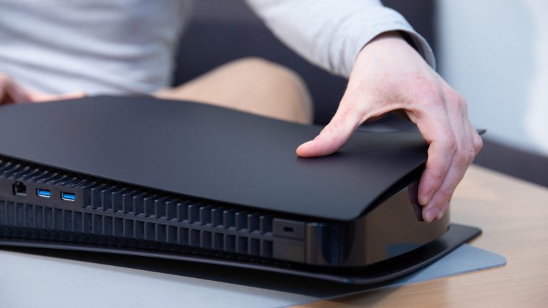 PlayStation 5: So wechselst du die Seitenteile Eine Person arretiert das zweite schwarze Seitenteil an einer PlayStation 5.