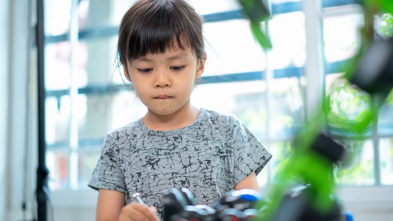Roboter für Kinder Ein Kind spielt mit einem Roboter.