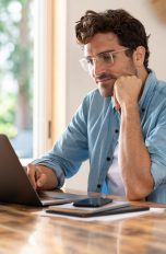 Eine Person blickt kritisch auf den Bildschirm ihres Laptops