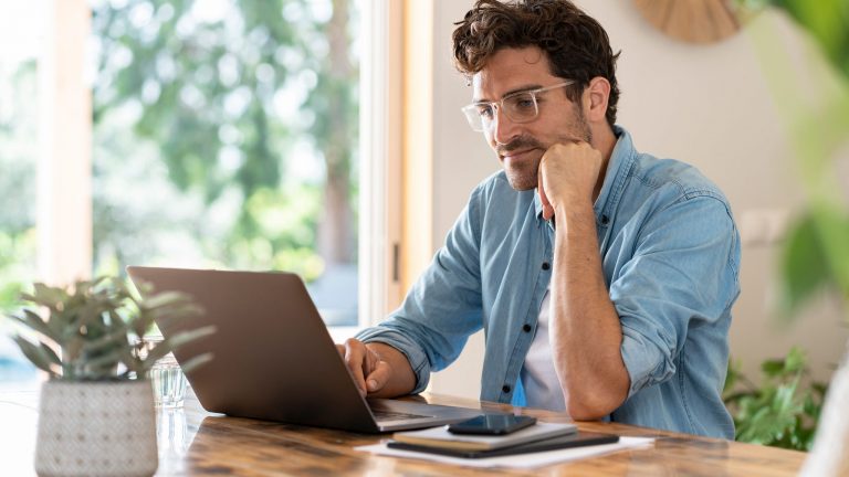 Eine Person blickt kritisch auf den Bildschirm ihres Laptops