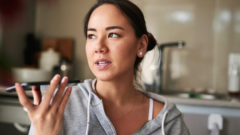Eine Person diktiert einen Text in ihr Smartphone.